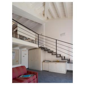 a living room with a staircase and a red couch at Hotel Margherita in Monterosso al Mare