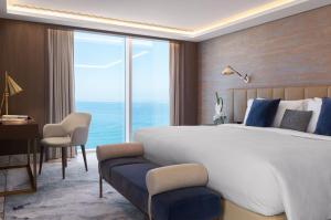 a bedroom with a large bed and a large window at Jumeirah Beach Hotel Dubai in Dubai