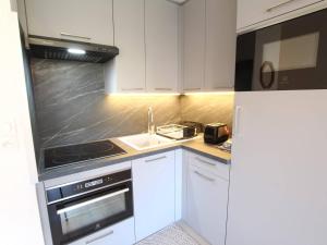 cocina con armarios blancos, fregadero y nevera en Appartement La Salle-les-Alpes, 1 pièce, 4 personnes - FR-1-330F-113 en Serre Chevalier