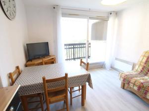 a living room with a table and a couch and a television at Appartement La Salle-les-Alpes, 1 pièce, 4 personnes - FR-1-330F-113 in Serre Chevalier