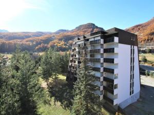 una vista aérea de un edificio con montañas en el fondo en Appartement La Salle-les-Alpes, 1 pièce, 4 personnes - FR-1-330F-113 en Serre Chevalier