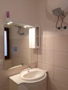 uma casa de banho branca com um lavatório e um espelho em Villette AmareSardegna Rei Playa em Costa Rei