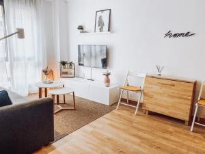 - un salon avec un canapé et une télévision dans l'établissement Monte Cerrau, apartamento con plaza de garaje y WIFI, à Oviedo