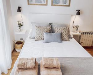 - une chambre avec un grand lit blanc et 2 oreillers dans l'établissement Monte Cerrau, apartamento con plaza de garaje y WIFI, à Oviedo