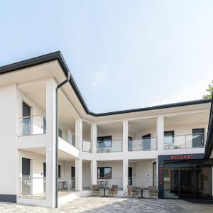 an external view of a building with tables and chairs at Jam Panzió in Kapuvár