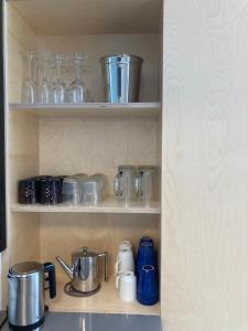 een keukenplank met glazen en potten en pannen bij LE GARAGE Downtown serviced apartment in Den Haag