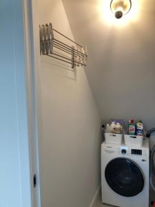 a laundry room with a washing machine and a light at LE GARAGE Downtown serviced apartment in The Hague