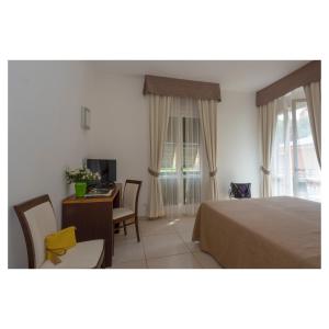 a bedroom with a bed and a table and a desk at Hotel Margherita in Monterosso al Mare