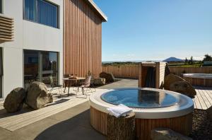 a patio with a hot tub next to a building at Mývatn - Berjaya Iceland Hotels in Myvatn