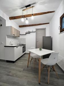 una cucina con tavolo e sedie in una stanza di B&b La casett a Crotone