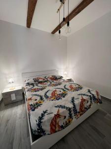 een witte slaapkamer met een bed met een dekbed bij B&b La casett in Crotone