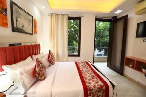a bedroom with a white bed with red pillows at Hotel Nature View Green Park Metro Couple Friendly New Delhi in New Delhi