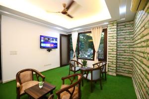 Cette chambre est dotée de chaises, de tables et d'un mur en briques. dans l'établissement Hotel Nature View Green Park Metro Couple Friendly New Delhi, à New Delhi