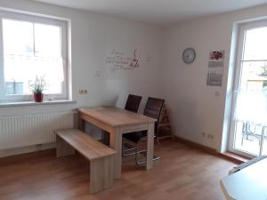Ferienwohnung - August-Bebel-Str. 19 في Oelsnitz: غرفة مع طاولة وكرسي ونوافذ اثنين