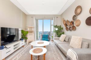 a living room with a couch and a tv at Tyrwhitt Luxury Apartment in Rosebank in Johannesburg