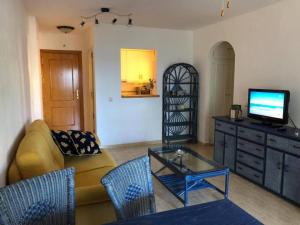 a living room with a couch and a tv on a dresser at Flat Sleeps 4 with Pool and Terrace in Mijas Costa