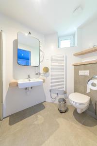 a bathroom with a toilet and a sink and a mirror at Jam Panzió in Kapuvár