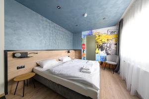 um quarto com uma cama grande e uma parede azul em Jam Panzió em Kapuvár