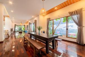 ホイアンにあるPuravida Villa Hoi An 2のテーブルと大きな窓のあるダイニングルーム
