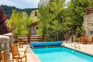 una piscina en un patio trasero con sillas y mesa en Deer Valley Chalet en Park City