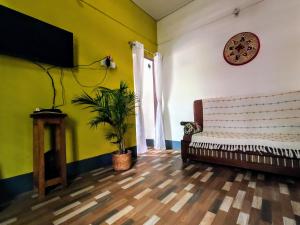 Stargaze Backpackers Hostel في غاواهاتي: غرفة معيشة مع أريكة وساعة على الحائط