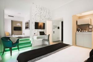 a bedroom with a bed and a desk and a kitchen at Montenapoleone Suites in Milan