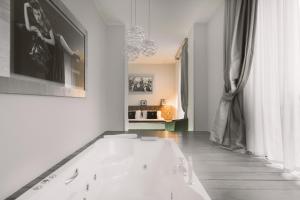 een badkamer met een wit bad in een kamer bij Montenapoleone Suites in Milaan