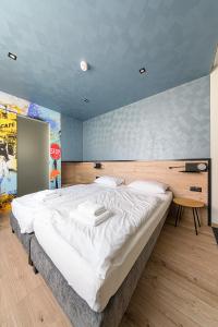 1 dormitorio con 1 cama grande en una habitación con una señal de stop en Jam Panzió, en Kapuvár