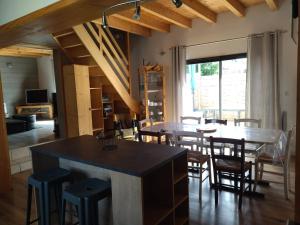 cocina y comedor con mesa y sillas en Maison familiale au centre de Loudenvielle en Loudenvielle