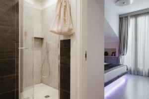 a bathroom with a shower and a walk in shower at Montenapoleone Suites in Milan