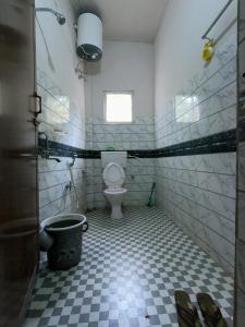 a bathroom with a toilet and a window at Stargaze Backpackers Hostel in Guwahati