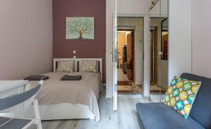 - une chambre avec un lit, une chaise et un miroir dans l'établissement Goldcentral Apartments Akacfa Studios, à Budapest