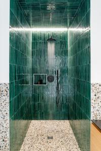 a bathroom with a shower with green tiles at DOM1872 apartments in Trieste