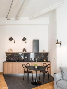 een keuken met een tafel en stoelen in de woonkamer bij DOM1872 apartments in Trieste
