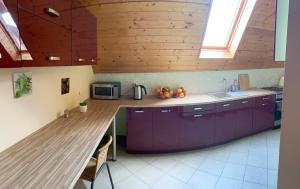 a kitchen with purple cabinets and a wooden counter top at NOCLEGI Grojec in Grojec