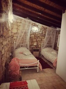 a bedroom with two beds in a stone wall at Kazani House Lofou in Lofou