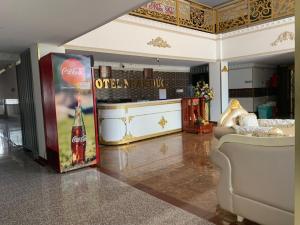 OYO 1170 Nhan Duc Hotel في مدينة هوشي منه: غرفة معيشة مع علامة كولا كوكا وأريكة
