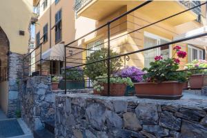 a building with potted plants on a stone wall at Hotel Margherita in Monterosso al Mare