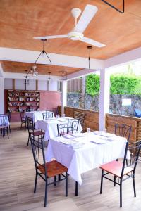 a dining room with white tables and chairs at Maison Du Nord in Pointe aux Canonniers