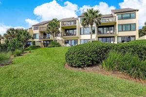 a large apartment building with palm trees and grass at 1029 Captains Court in Fernandina Beach