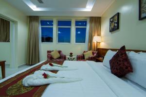Säng eller sängar i ett rum på Rose Emerald Hotel
