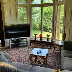 a living room with a flat screen tv and a couch at Country Manor House with indoor Pool and Hot Tub in Rochester