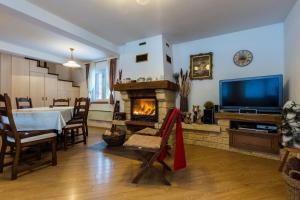 a living room with a dining table and a fireplace at Holiday Home Nina with a heated pool in Brušane