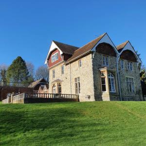 a large stone house with a green field in front of it at Country Manor House with indoor Pool and Hot Tub in Rochester