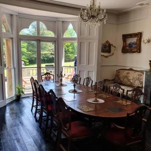 a dining room with a table and chairs and a couch at Country Manor House with indoor Pool and Hot Tub in Rochester
