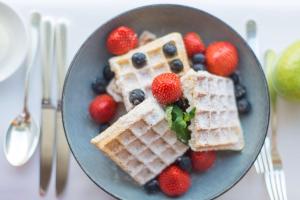 a plate of waffles and berries on a table at Grand Hyatt Berlin in Berlin