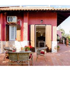 奧古斯塔的住宿－Villa Angela，前面有一张桌子和椅子的红色房子