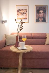 a coffee table with a glass of wine and a couch at Apartament Grzaniec in Szklarska Poręba