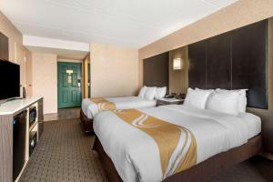 a hotel room with two beds and a flat screen tv at Quality Inn Montgomeryville-Philadelphia in Montgomeryville