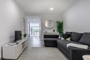 a living room with a couch and a tv at Costa Mar III in Peniche